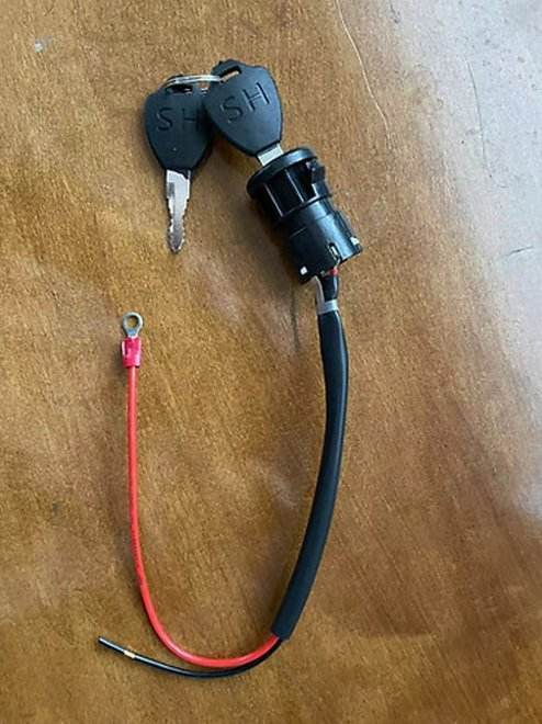 Lock and key set for floor scrubber machines with wiring harness on wooden surface