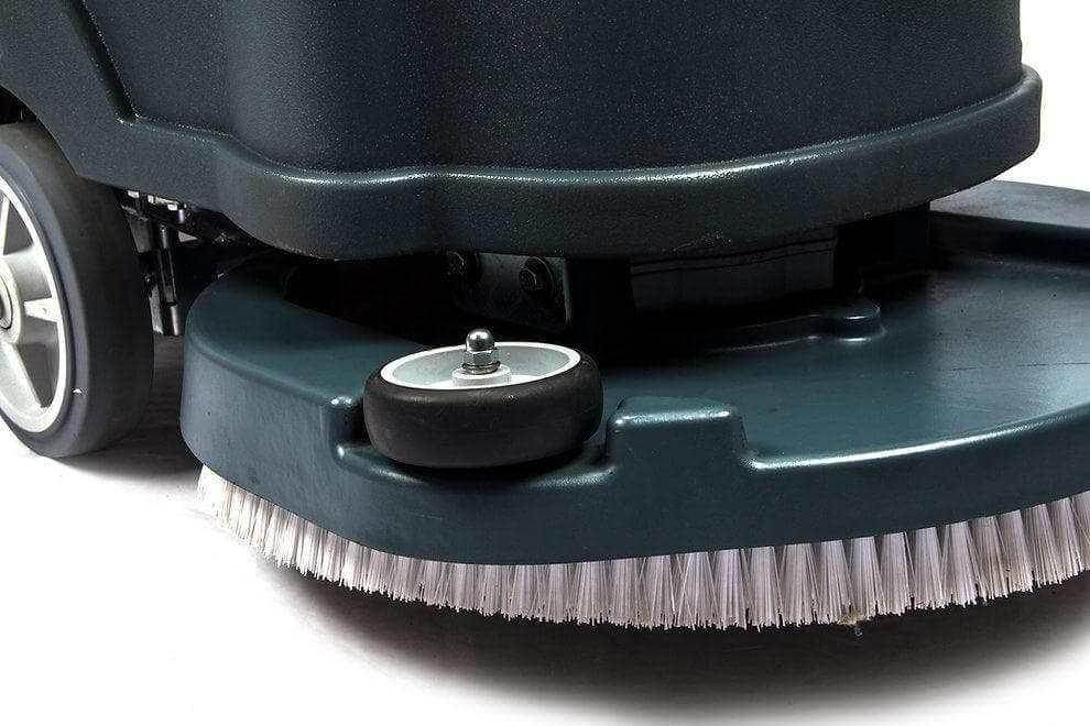Close-up of the RT50 battery powered walk-behind floor scrubber's 22-inch brush deck and wheels.