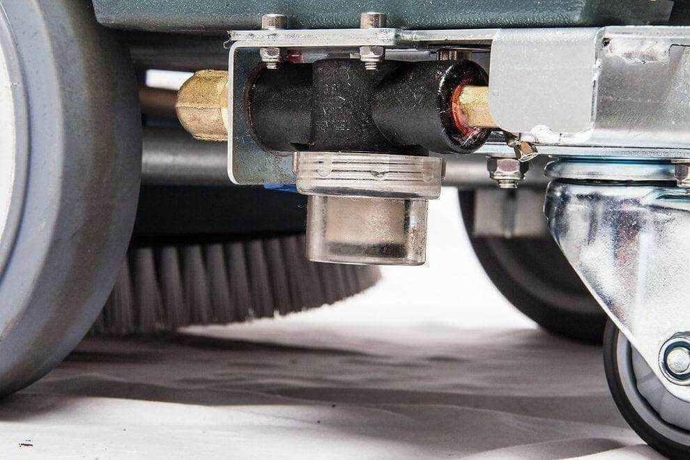 Close-up view of RT50 battery powered walk-behind floor scrubber brush and caster wheel assembly for commercial cleaning.